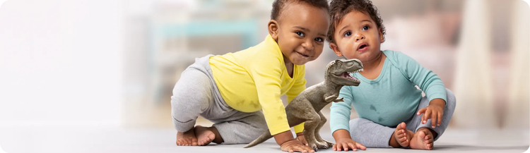 Two infants engaging in play with a dinosaur toy on the floor.