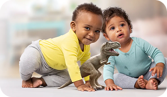 Two infants engaging in play with a dinosaur toy on the floor.
